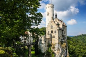 White castle on a rocky outcrop surrounded by trees