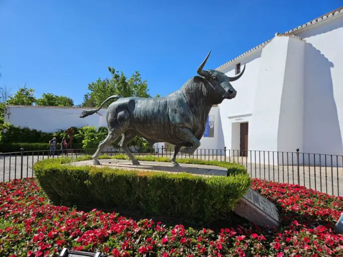 Statue of a bull next to a white wall