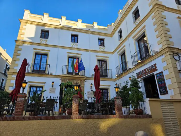 White building with yellow decoration and flags outside