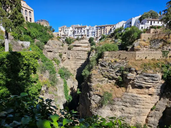 Steep cliffs covered in green foliage with white houses on top