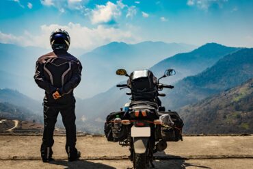 Man standing next to motorbike in the mountains