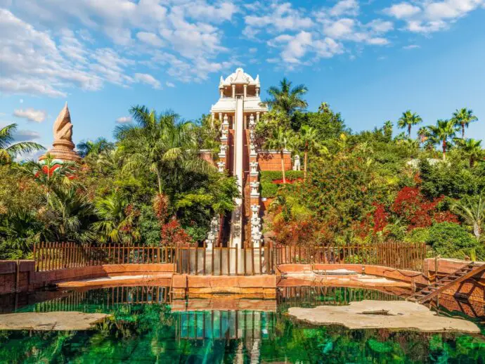 Water flume shaped like a Thai temple with jungle greenery and a blue pool at the bottom