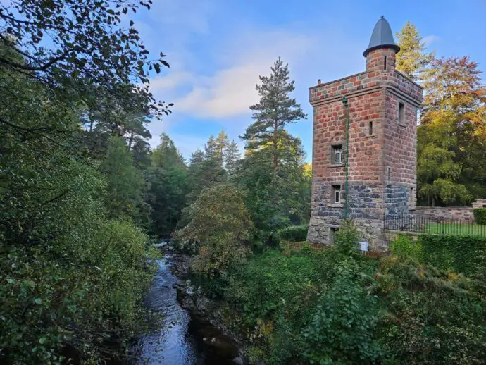 Red brick tower in a forest beside a river