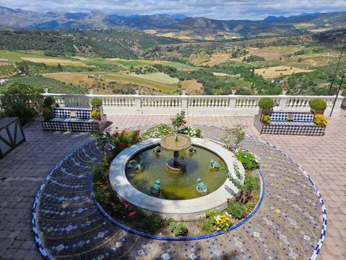 Garden patio terrace with a circular fountain and mountains in the distance