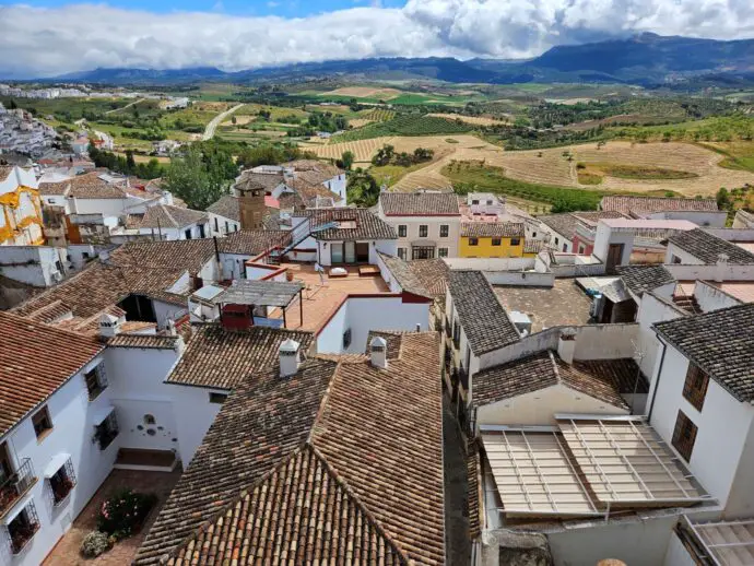 View overlooking red rooftops on white houses with green countryside in the distance