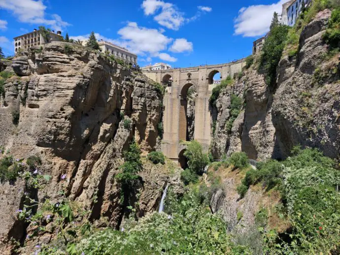 Stone bridge across a deep gorge with a waterfall beneath